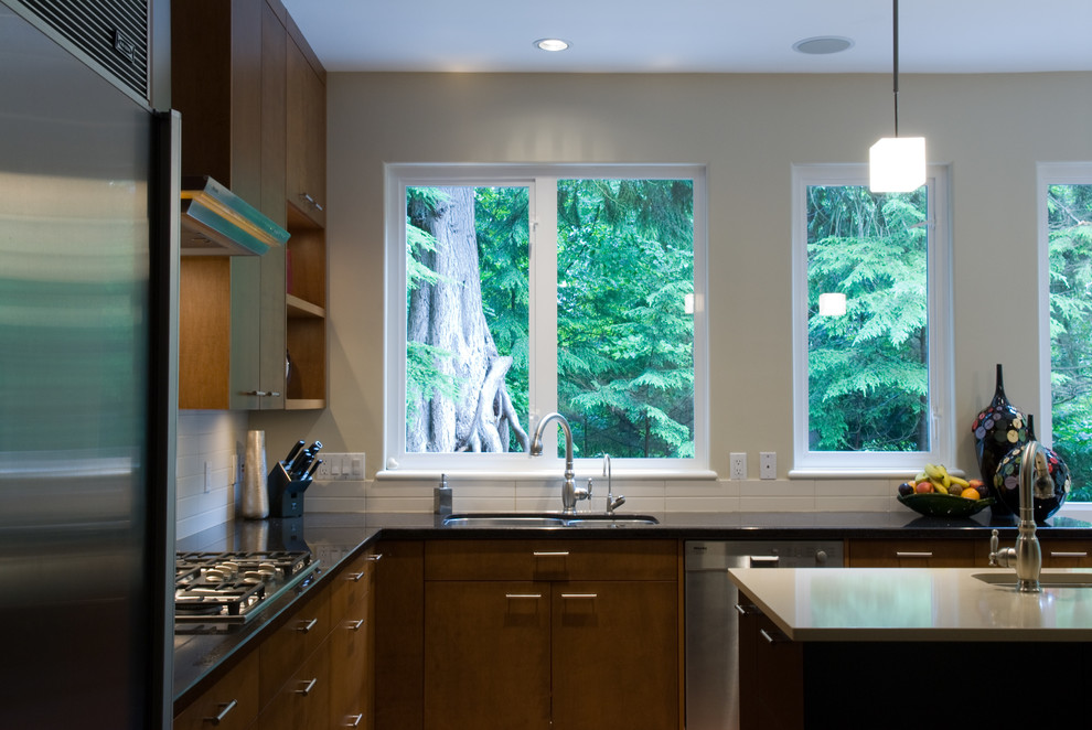 This is an example of a contemporary l-shaped separate kitchen in Vancouver with an undermount sink, flat-panel cabinets, medium wood cabinets, quartz benchtops, white splashback, ceramic splashback and stainless steel appliances.