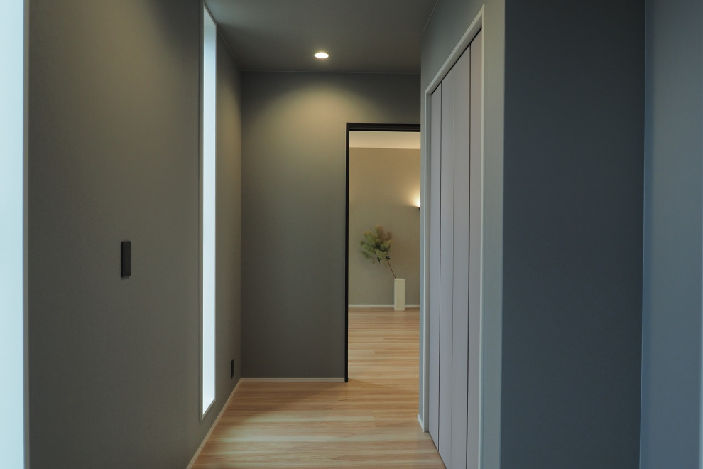 Imagen de hall gris minimalista con paredes grises, suelo de baldosas de cerámica, puerta simple, puerta marrón, suelo gris, papel pintado y papel pintado