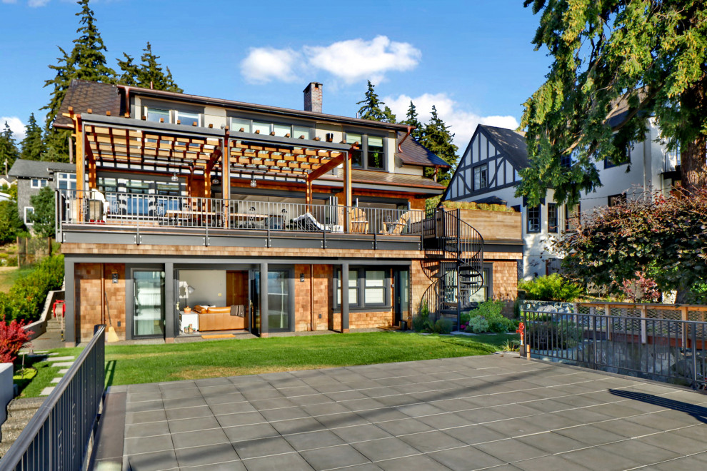 Ejemplo de fachada de casa multicolor y marrón de estilo americano grande de tres plantas con revestimientos combinados, tejado a dos aguas, tejado de metal y teja