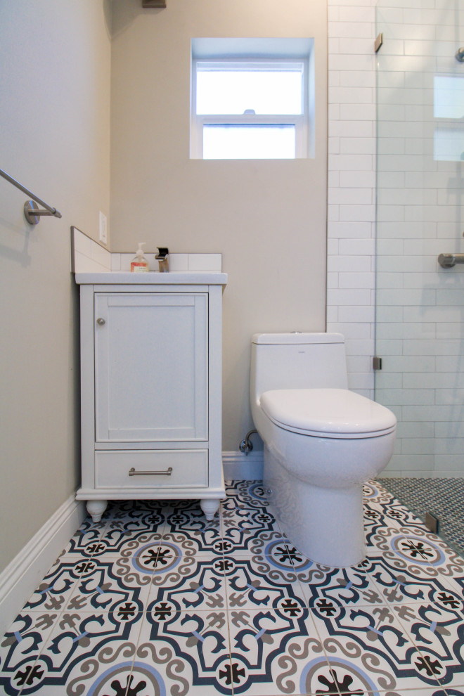 Inspiration for a small contemporary 3/4 bathroom in Los Angeles with recessed-panel cabinets, white cabinets, a corner shower, a one-piece toilet, white tile, ceramic tile, beige walls, a drop-in sink, granite benchtops, white floor, an open shower, white benchtops, a single vanity, a freestanding vanity, ceramic floors and a niche.