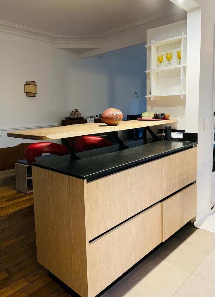 Photo of a medium sized contemporary u-shaped kitchen/diner in Paris with an integrated sink, beaded cabinets, light wood cabinets, granite worktops, granite splashback, black appliances, ceramic flooring, an island, grey floors and black worktops.
