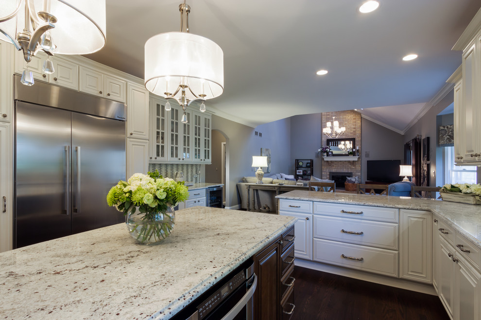 Kitchen - large transitional u-shaped dark wood floor kitchen idea in Chicago with a double-bowl sink, raised-panel cabinets, white cabinets, granite countertops, gray backsplash, subway tile backsplash, stainless steel appliances and an island