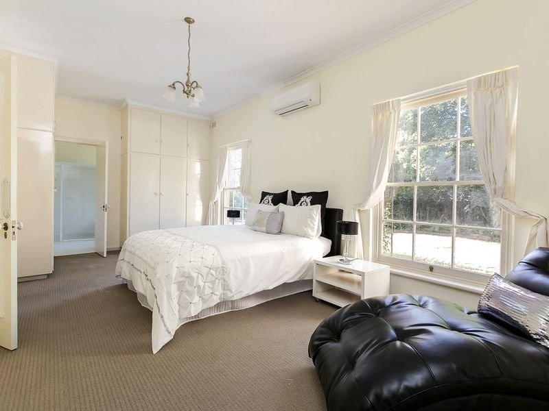 Inspiration for a large traditional bedroom in Adelaide with beige walls and carpet.