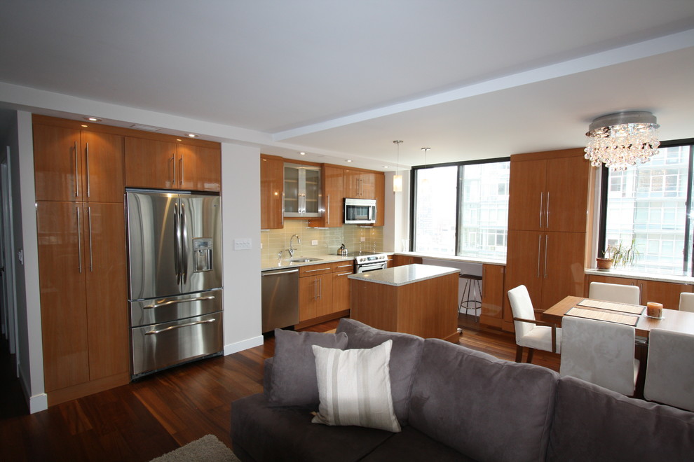 Open concept kitchen - small modern single-wall medium tone wood floor open concept kitchen idea in New York with stainless steel appliances, an island, an undermount sink, flat-panel cabinets, light wood cabinets, granite countertops, green backsplash and glass tile backsplash