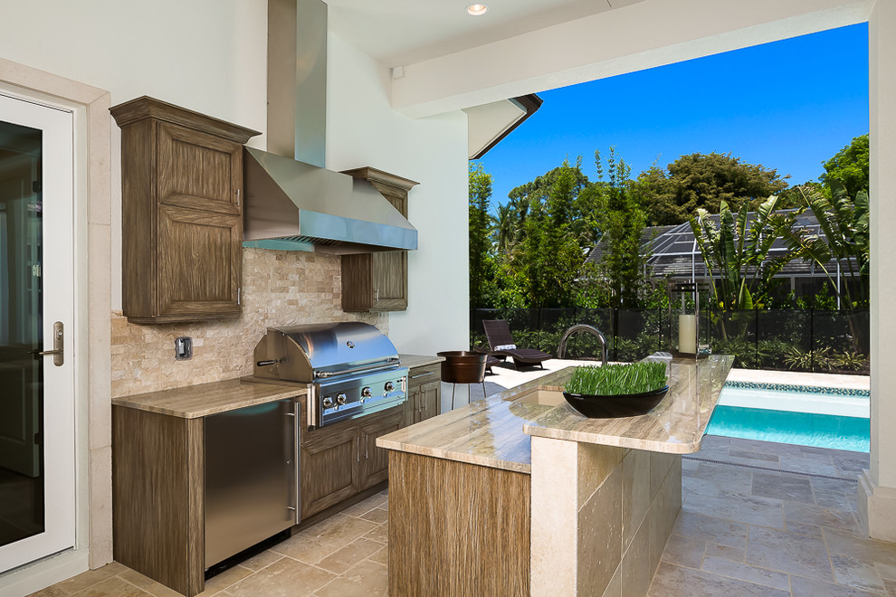 Inspiration for a large tropical courtyard patio in Miami with an outdoor kitchen, tile and a roof extension.