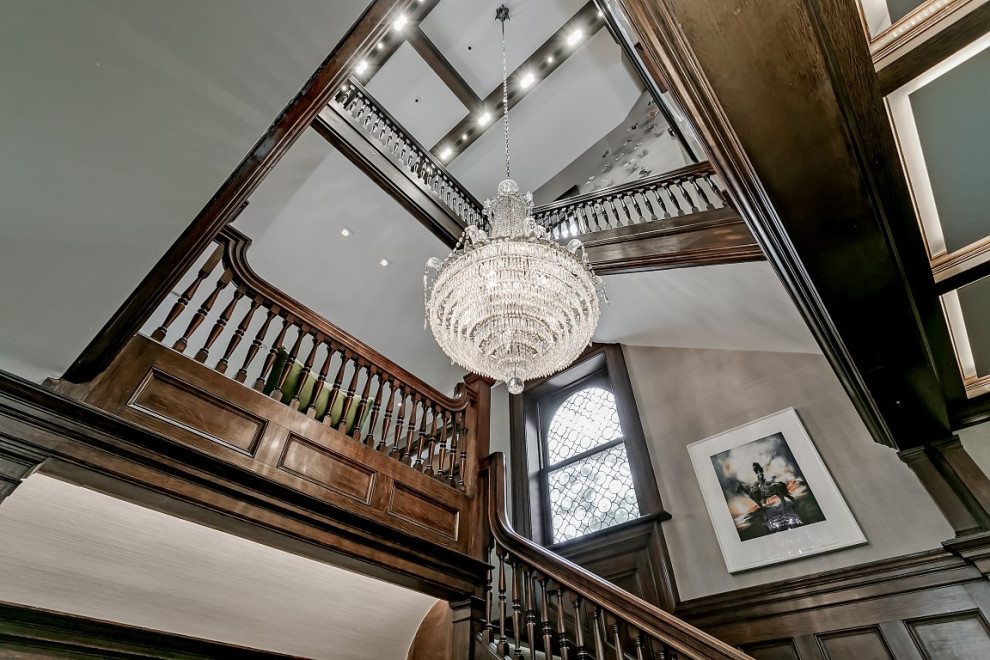 Expansive traditional wood u-shaped staircase in Toronto with wood risers and wood railing.