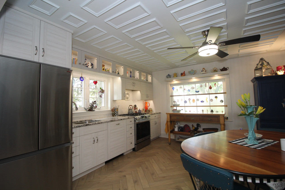Inspiration för mellanstora amerikanska linjära beige kök och matrum, med en undermonterad diskho, skåp i shakerstil, beige skåp, granitbänkskiva, beige stänkskydd, stänkskydd i mosaik, rostfria vitvaror, vinylgolv och brunt golv