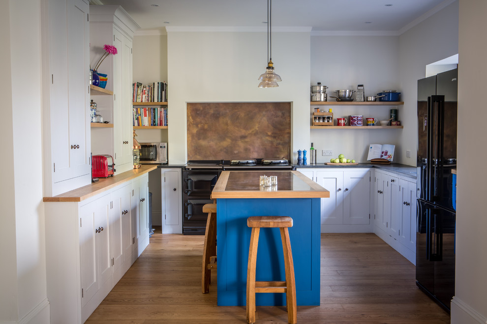 Large transitional u-shaped eat-in kitchen in Other with shaker cabinets, grey cabinets, granite benchtops, black appliances, with island, an undermount sink, metallic splashback, metal splashback and light hardwood floors.