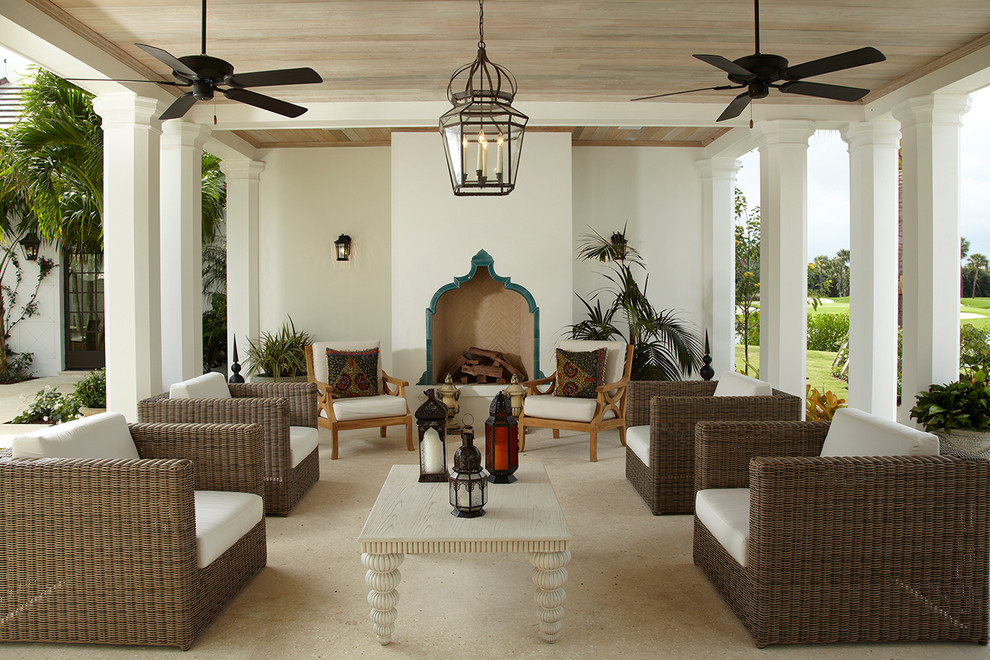 Design ideas for a mediterranean patio in Miami with with fireplace.