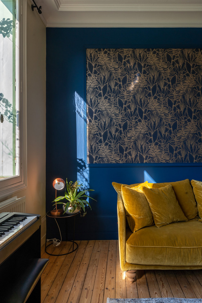 Inspiration pour un salon vintage de taille moyenne et fermé avec un mur bleu, parquet clair, une cheminée, un manteau de cheminée en pierre, un téléviseur indépendant et du papier peint.