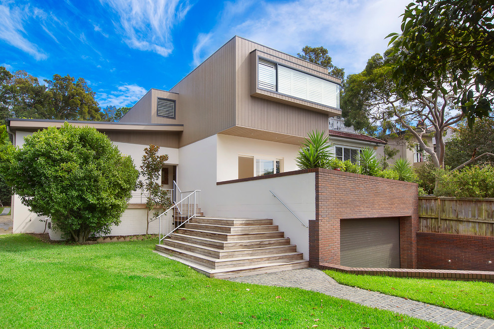 Photo of a contemporary three-storey white exterior in Sydney with concrete fiberboard siding and a flat roof.