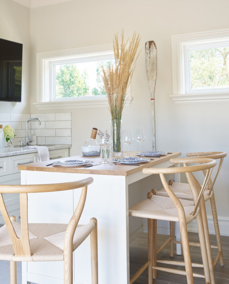 Mid-sized transitional u-shaped vinyl floor and brown floor eat-in kitchen photo with an undermount sink, shaker cabinets, white cabinets, marble countertops, white backsplash, subway tile backsplash, an island and gray countertops