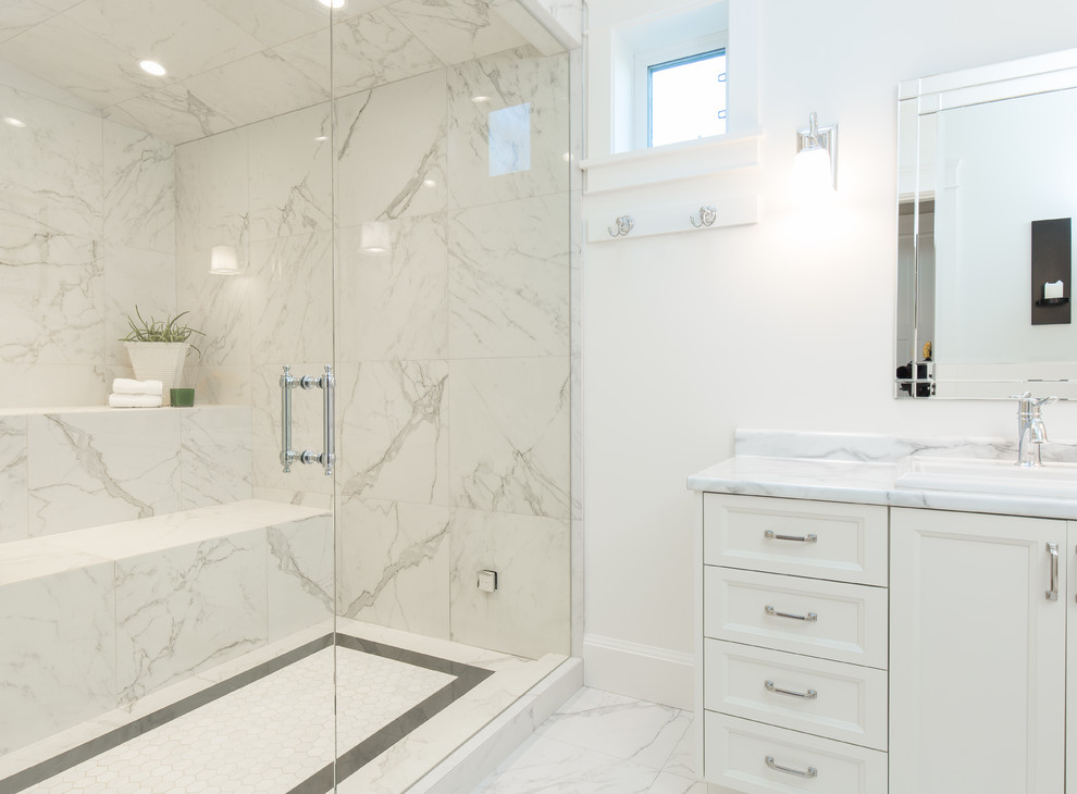 Inspiration for a large modern master bathroom in Vancouver with recessed-panel cabinets, white cabinets, marble, white walls, marble floors, a drop-in sink, marble benchtops, an alcove shower, a hinged shower door, white tile, white floor and white benchtops.