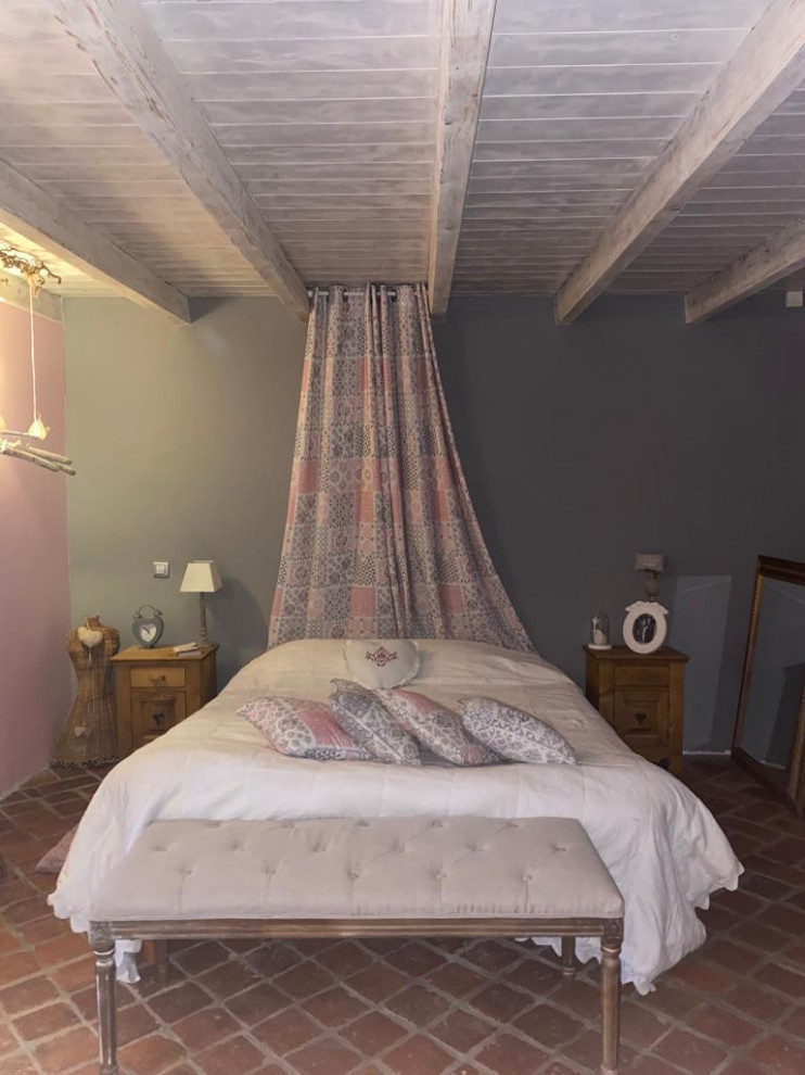 Пример оригинального дизайна: хозяйская спальня среднего размера в стиле шебби-шик с розовыми стенами, полом из терракотовой плитки, красным полом и балками на потолке без камина
