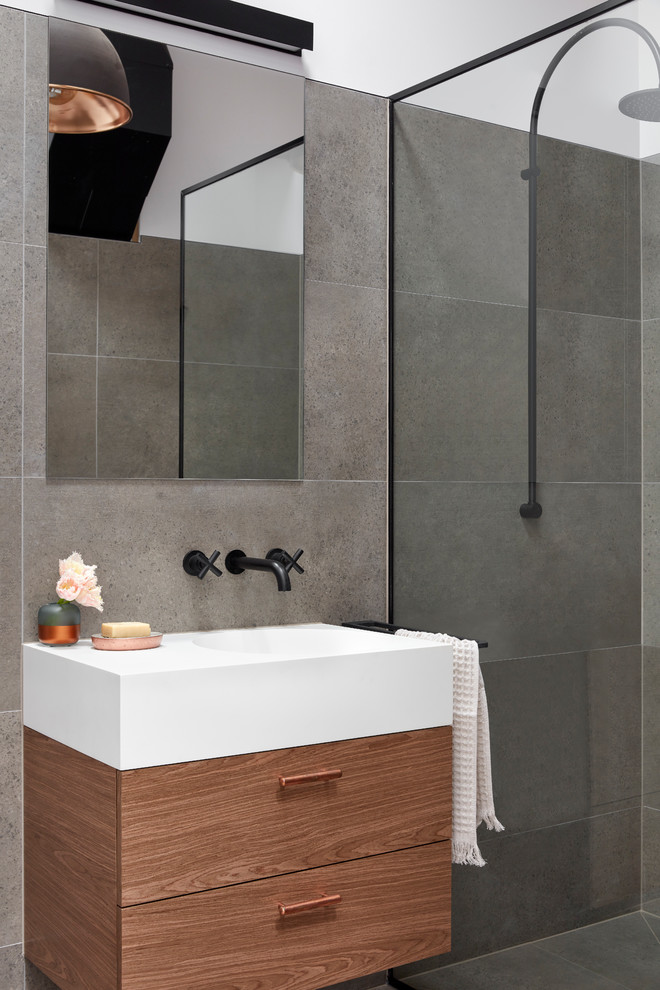 Design ideas for a small industrial 3/4 bathroom in Melbourne with flat-panel cabinets, dark wood cabinets, an open shower, a one-piece toilet, gray tile, porcelain tile, porcelain floors, an integrated sink, solid surface benchtops, grey floor and an open shower.