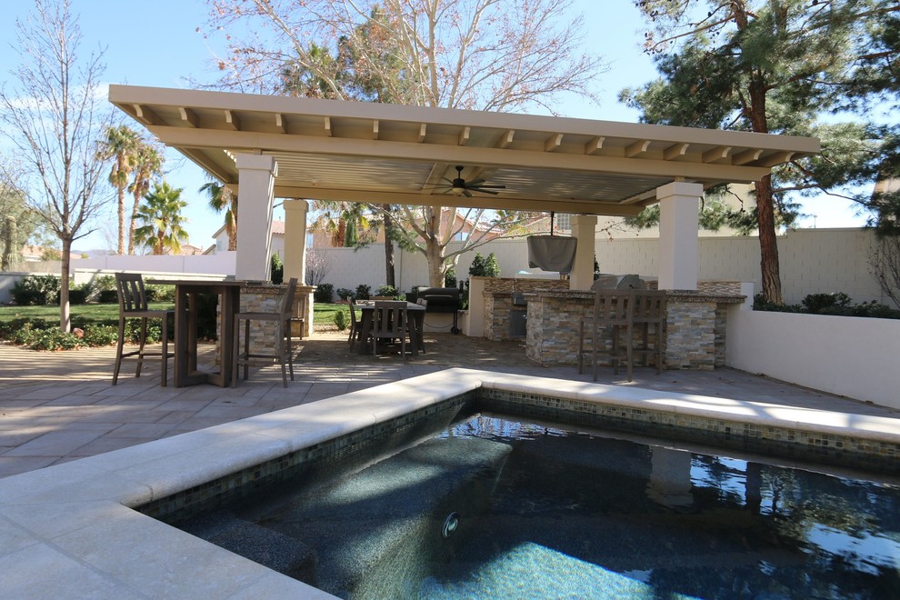 This is an example of a large traditional backyard patio in Dallas with an outdoor kitchen, stamped concrete and a pergola.