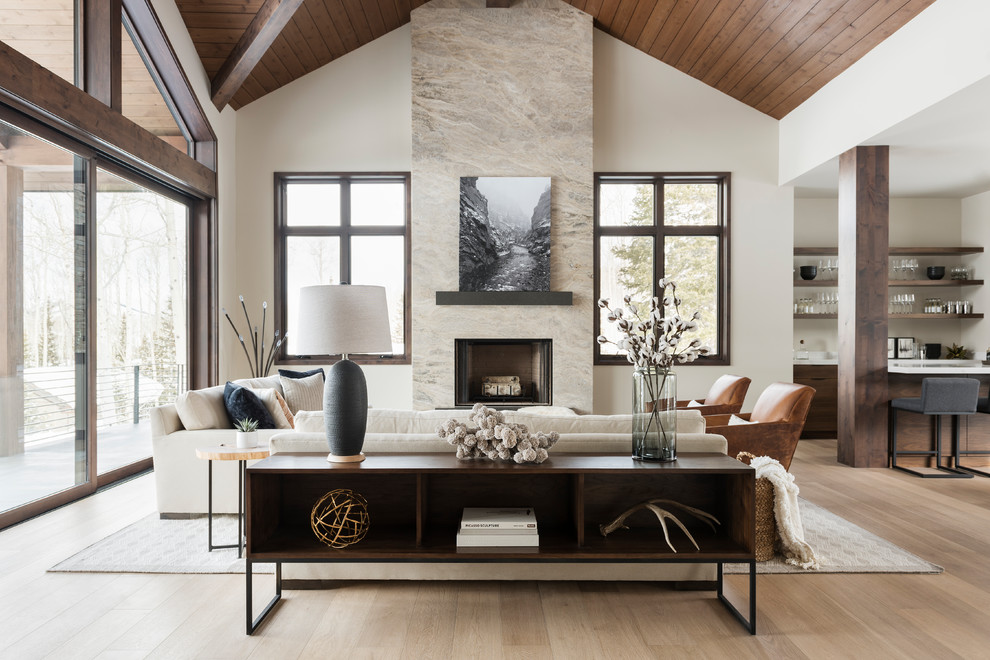 Photo of a large contemporary open concept living room in Salt Lake City with a home bar, beige walls, medium hardwood floors, a standard fireplace, a stone fireplace surround, beige floor and no tv.