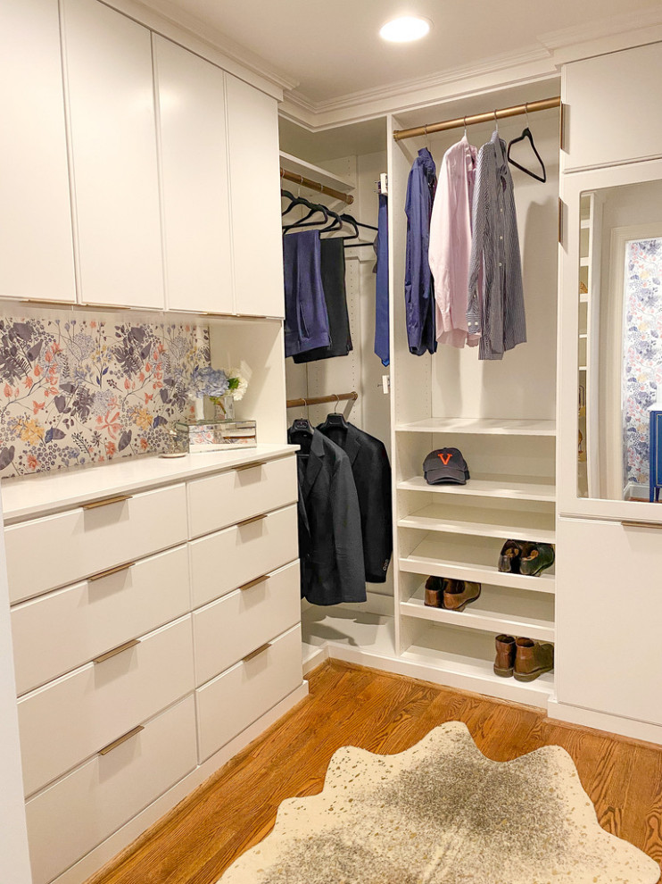Example of a small medium tone wood floor walk-in closet design in Raleigh with flat-panel cabinets and white cabinets