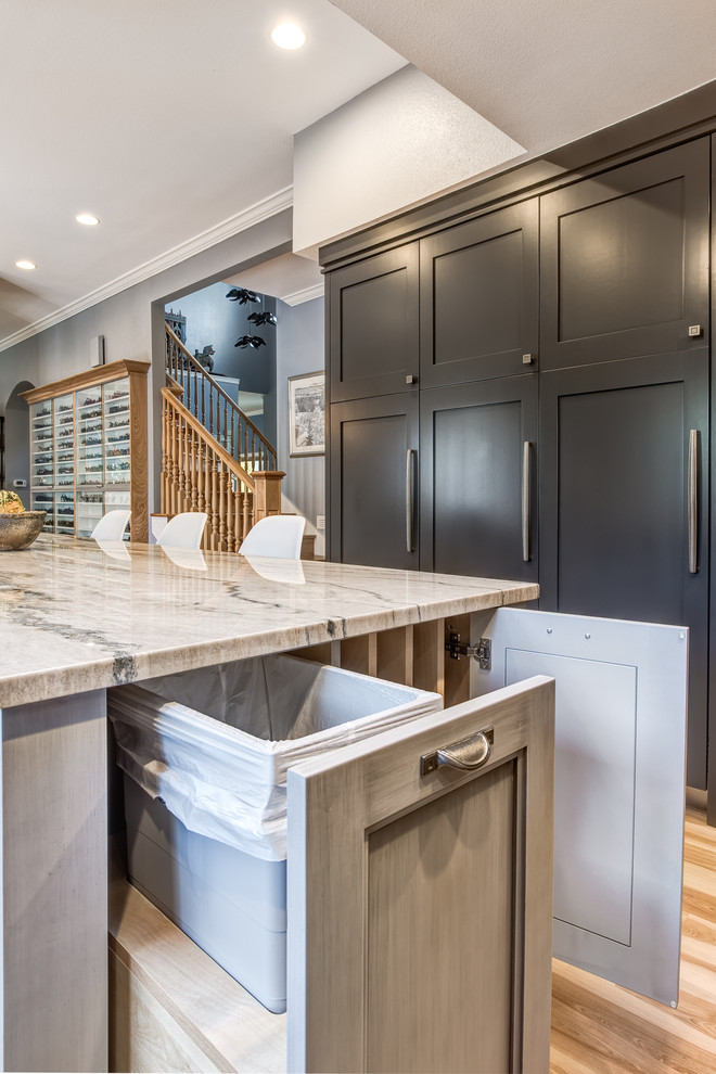 Large transitional u-shaped light wood floor eat-in kitchen photo in Denver with a farmhouse sink, recessed-panel cabinets, gray cabinets, quartzite countertops, blue backsplash, ceramic backsplash, stainless steel appliances and an island
