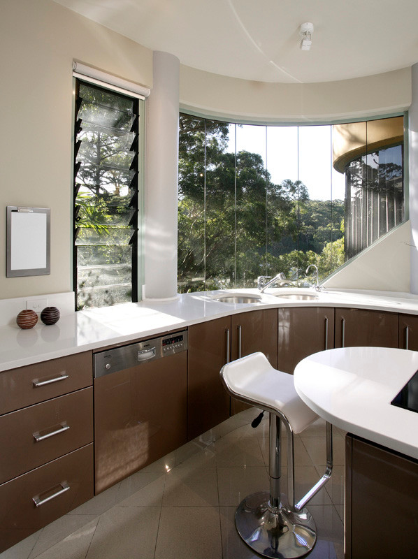 This is an example of a mid-sized modern u-shaped kitchen pantry in Sydney with an undermount sink, flat-panel cabinets, brown cabinets, quartzite benchtops, white splashback, stone slab splashback, stainless steel appliances, porcelain floors and with island.