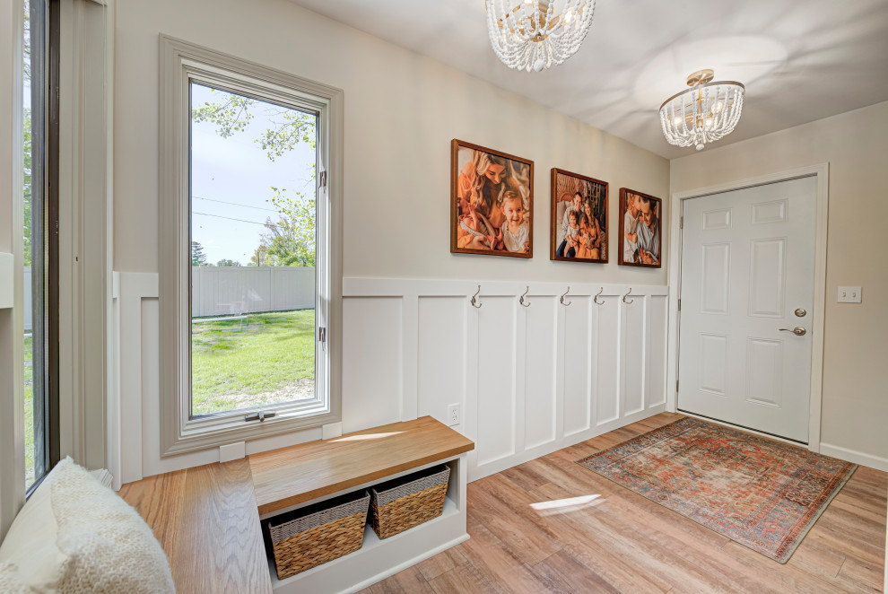 Ejemplo de puerta principal tradicional de tamaño medio con paredes beige, puerta simple, puerta de madera en tonos medios, suelo de madera en tonos medios, suelo beige y boiserie