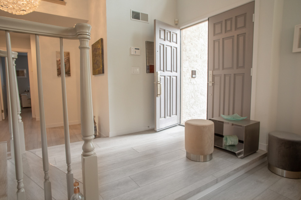 This is an example of a large traditional front door in San Francisco with white walls, vinyl floors, a double front door, a gray front door, grey floor and vaulted.