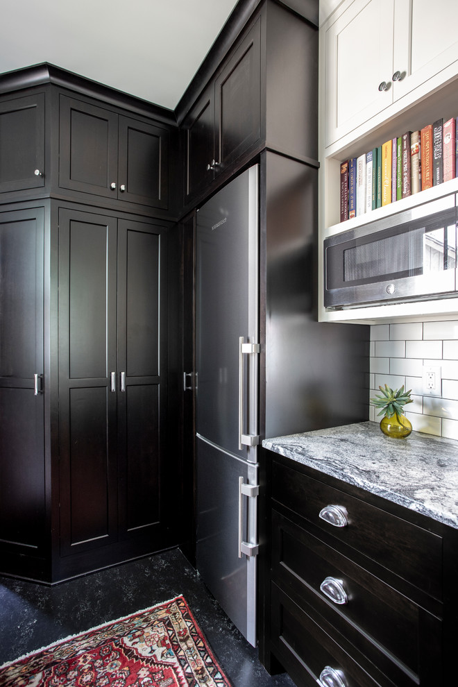 Design ideas for a small traditional u-shaped separate kitchen in Minneapolis with an undermount sink, recessed-panel cabinets, black cabinets, granite benchtops, yellow splashback, subway tile splashback, stainless steel appliances, linoleum floors, black floor and white benchtop.