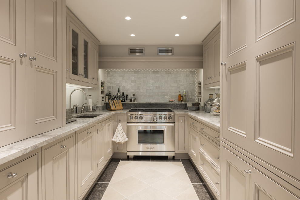 Traditional galley separate kitchen in London with an undermount sink, recessed-panel cabinets, beige cabinets, grey splashback, subway tile splashback, stainless steel appliances and no island.