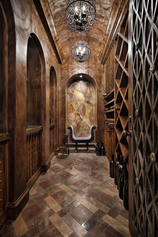 Photo of a mediterranean wine cellar in Dallas with diamond bins and brown floor.