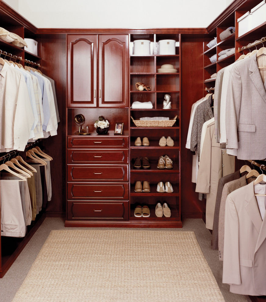 Large traditional gender-neutral walk-in wardrobe in Orange County with raised-panel cabinets and dark wood cabinets.