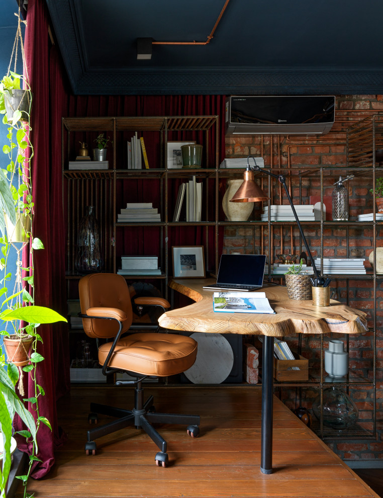 Idee per un ufficio industriale di medie dimensioni con pareti rosse, parquet scuro, scrivania incassata, pavimento marrone e pareti in mattoni
