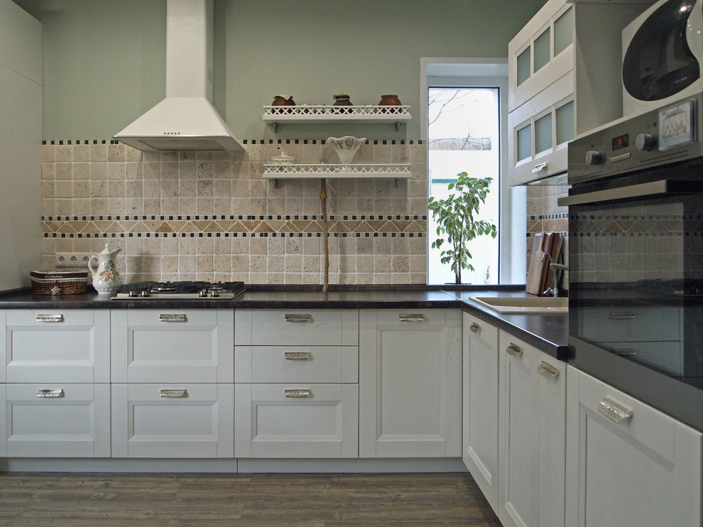 Inspiration for a mid-sized country l-shaped eat-in kitchen in Moscow with a drop-in sink, recessed-panel cabinets, white cabinets, beige splashback, travertine splashback, stainless steel appliances, laminate floors and grey floor.