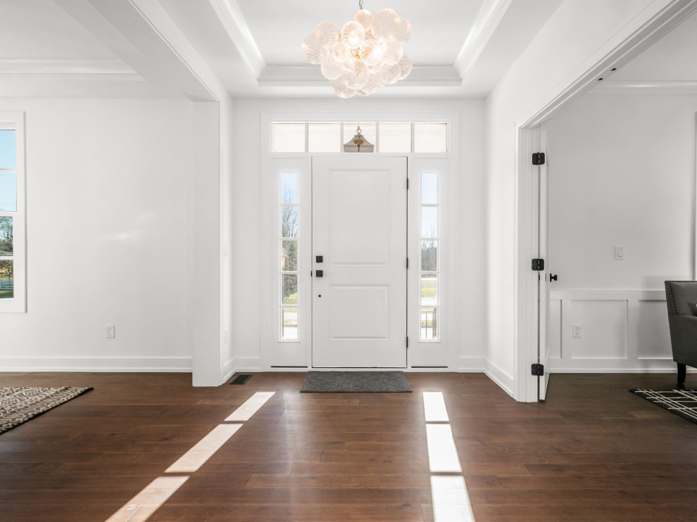 Inspiration pour une grande porte d'entrée traditionnelle avec un mur blanc, un sol en bois brun, une porte simple, une porte blanche, un sol blanc, un plafond décaissé et du lambris.