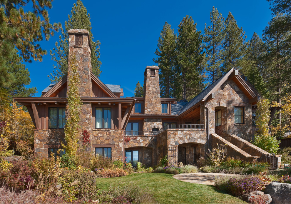 Design ideas for an expansive traditional three-storey brown exterior in Other with stone veneer.
