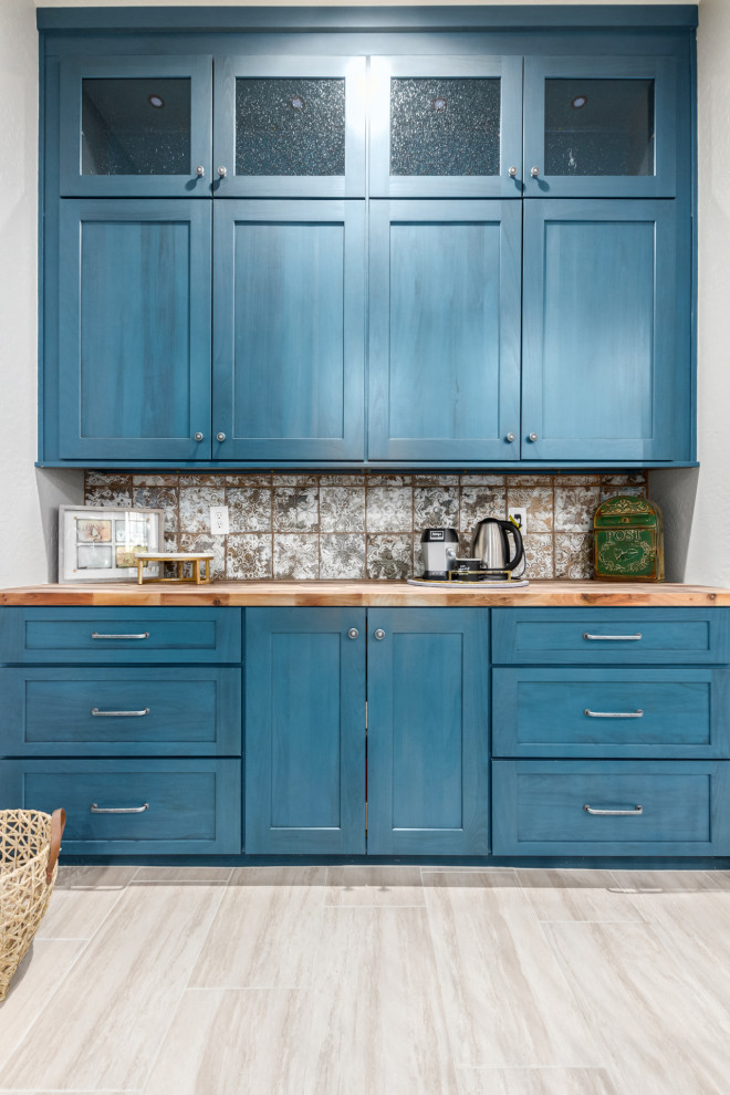 Expansive country l-shaped home bar in Phoenix with shaker cabinets, blue cabinets, wood benchtops, multi-coloured splashback, metal splashback and brown benchtop.