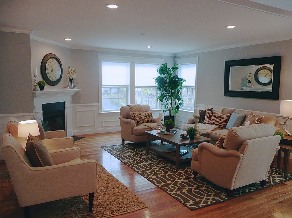 This is an example of a large traditional open concept living room in Boston with grey walls, light hardwood floors, a corner fireplace and no tv.