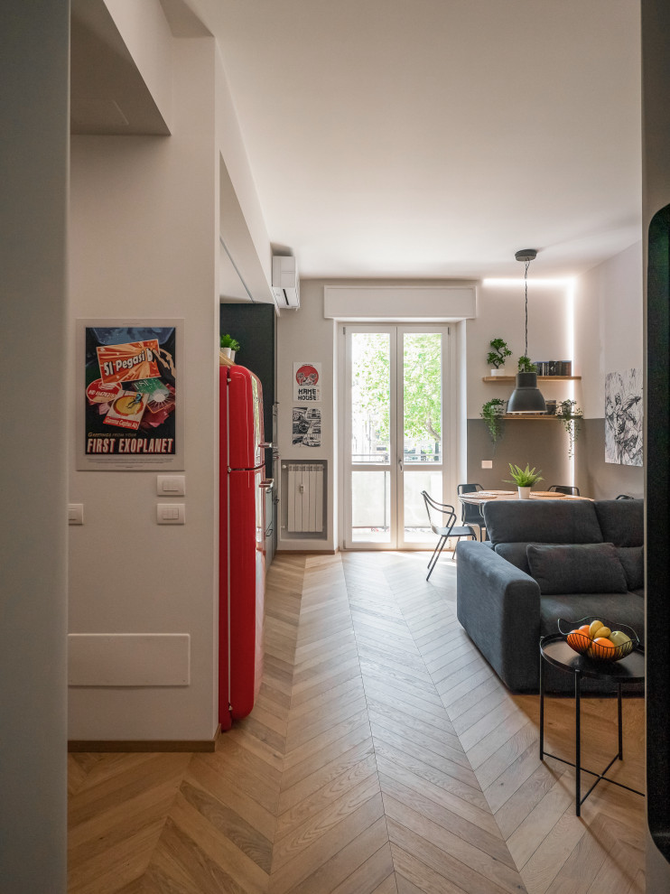 На фото: маленькая открытая гостиная комната в стиле лофт с серыми стенами, светлым паркетным полом, телевизором на стене и многоуровневым потолком для на участке и в саду