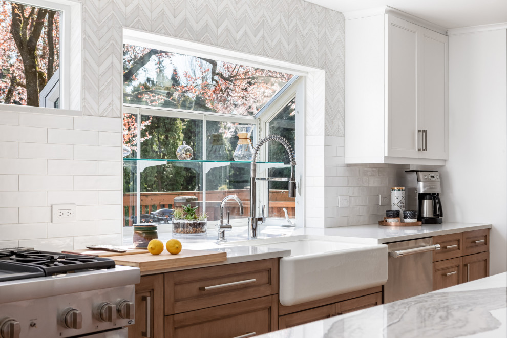 Inspiration for a large transitional light wood floor and brown floor kitchen remodel in Seattle with a farmhouse sink, medium tone wood cabinets, quartz countertops, white backsplash, mosaic tile backsplash, stainless steel appliances, an island and white countertops