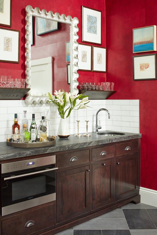 Small transitional single-wall wet bar in Boston with an undermount sink, shaker cabinets, dark wood cabinets, white splashback, subway tile splashback, grey floor, porcelain floors, marble benchtops and grey benchtop.