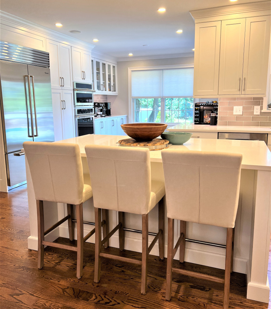 Example of a transitional kitchen design with an undermount sink, shaker cabinets, white cabinets and stainless steel appliances