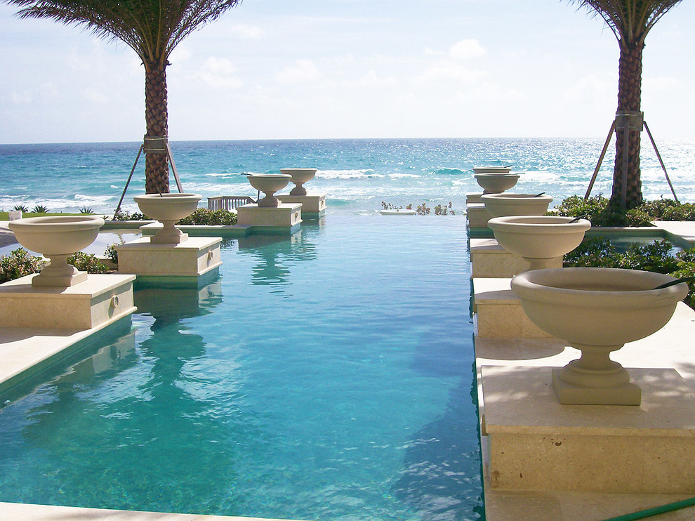 This is an example of a large mediterranean backyard rectangular infinity pool in Miami.