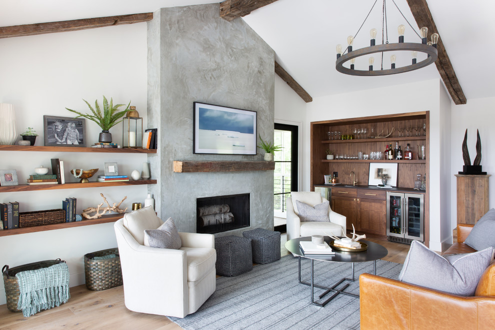 This is an example of a mid-sized transitional living room in Austin with white walls, medium hardwood floors, a standard fireplace, a concrete fireplace surround, a wall-mounted tv and brown floor.