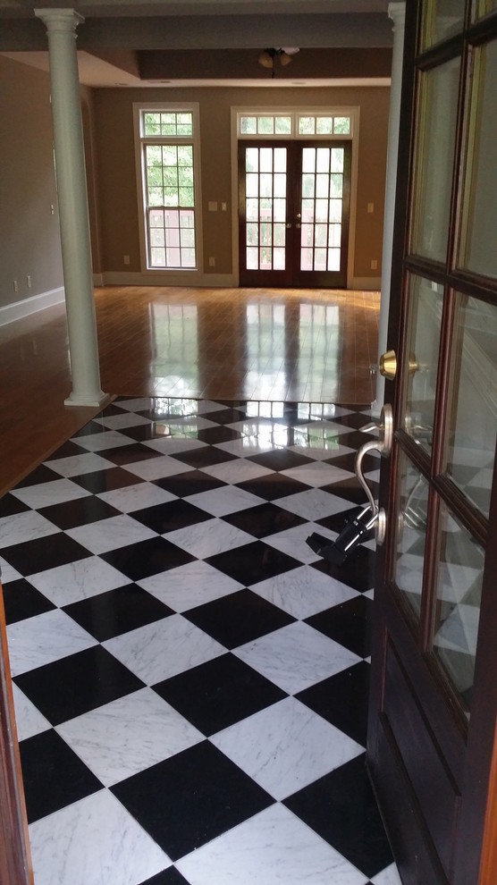 Example of a mid-sized transitional porcelain tile and multicolored floor foyer design in Albuquerque with beige walls and a dark wood front door
