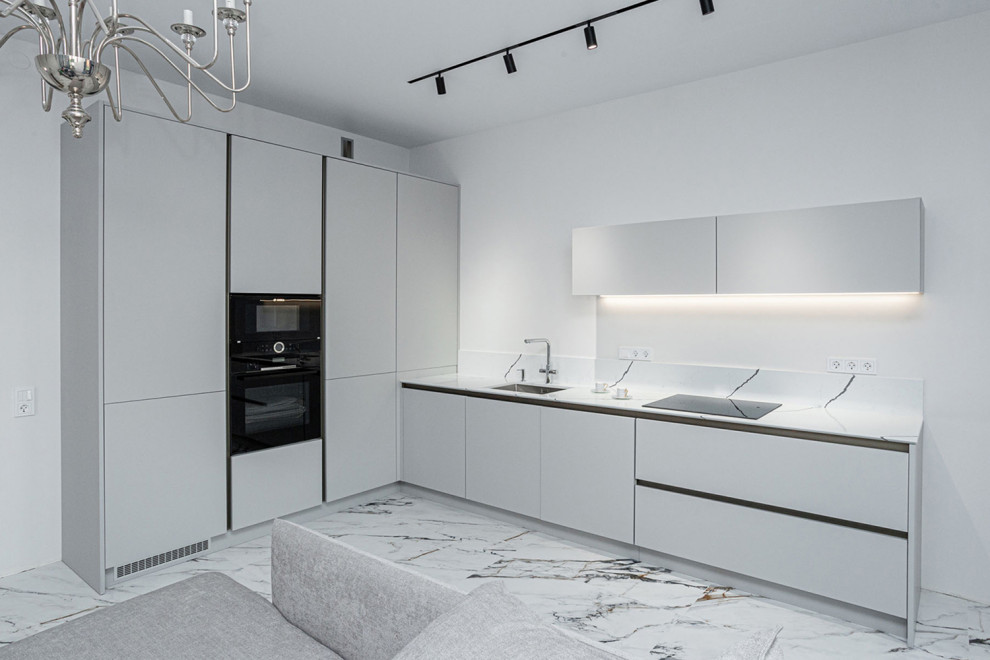 This is an example of a medium sized contemporary grey and white l-shaped enclosed kitchen in Saint Petersburg with a single-bowl sink, flat-panel cabinets, white cabinets, engineered stone countertops, white splashback, engineered quartz splashback, black appliances, porcelain flooring, no island, white floors and white worktops.