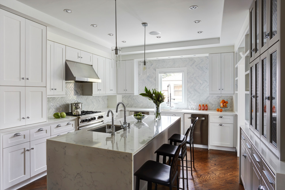 Eat-in kitchen - mid-sized transitional u-shaped medium tone wood floor eat-in kitchen idea in Chicago with an undermount sink, shaker cabinets, white cabinets, solid surface countertops, blue backsplash, stone tile backsplash, stainless steel appliances and an island