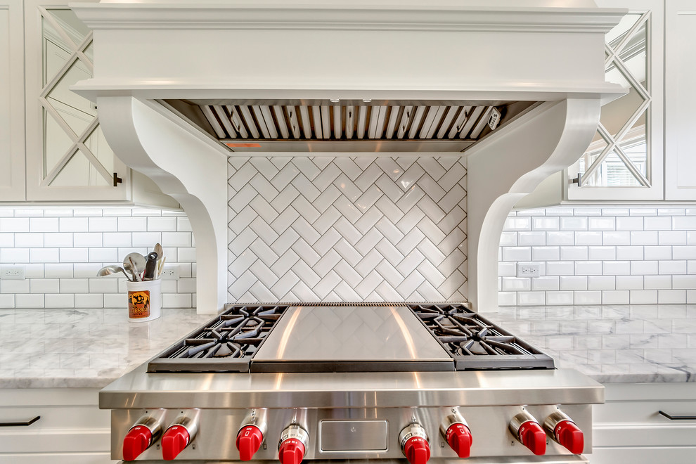 Example of a transitional open concept kitchen design in Chicago with white backsplash, subway tile backsplash and two islands