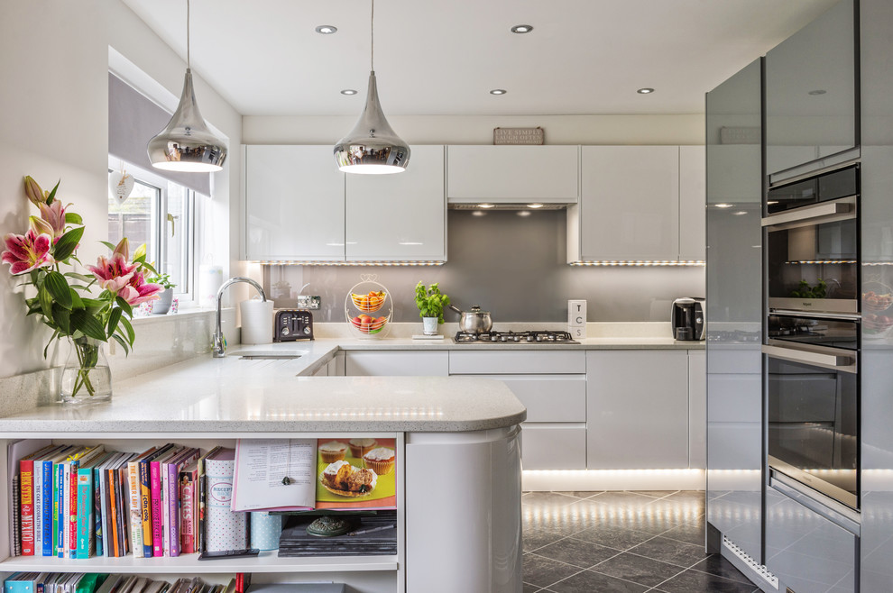 Inspiration for a mid-sized contemporary u-shaped kitchen in Other with an undermount sink, flat-panel cabinets, white cabinets, grey splashback, stainless steel appliances, grey benchtop, a peninsula and grey floor.