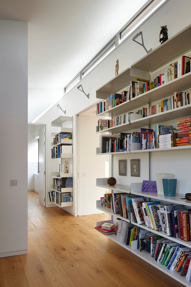 Mid-sized contemporary hallway in London with white walls, medium hardwood floors and brown floor.