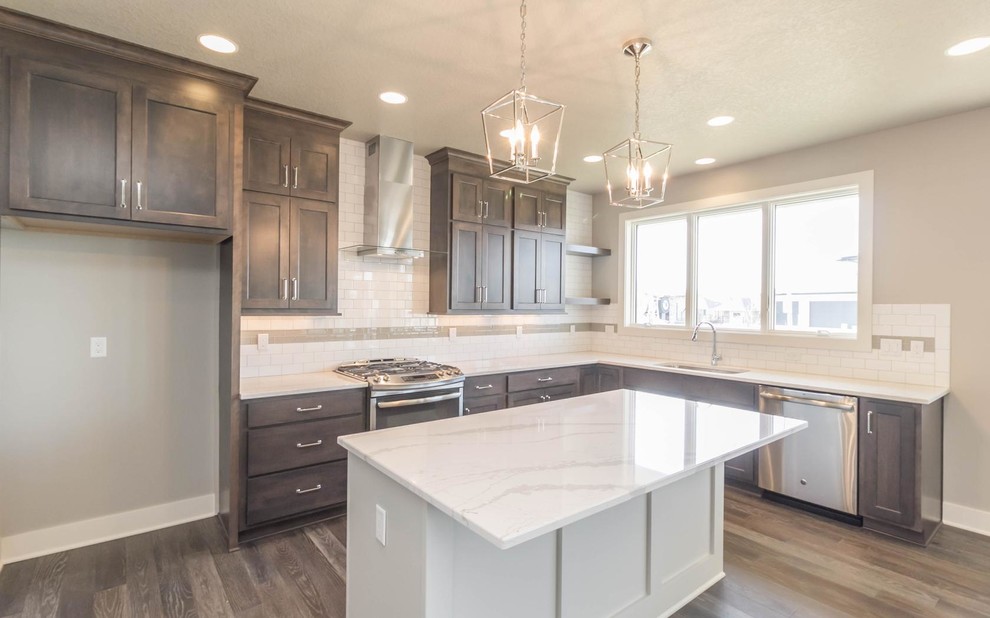 Inspiration for a mid-sized transitional l-shaped medium tone wood floor open concept kitchen remodel with an undermount sink, shaker cabinets, dark wood cabinets, marble countertops, white backsplash, subway tile backsplash, stainless steel appliances and an island