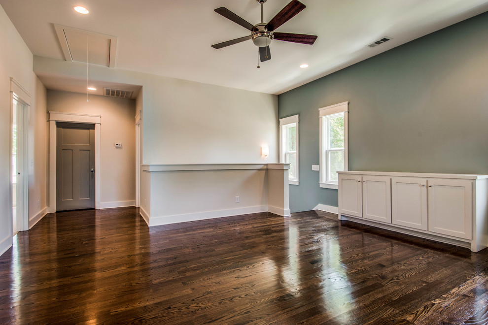 This is an example of a mid-sized transitional enclosed family room in Nashville with blue walls, medium hardwood floors, no fireplace and a wall-mounted tv.
